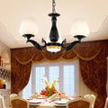 Ornate black & gold chandelier with frosted glass shades dining room