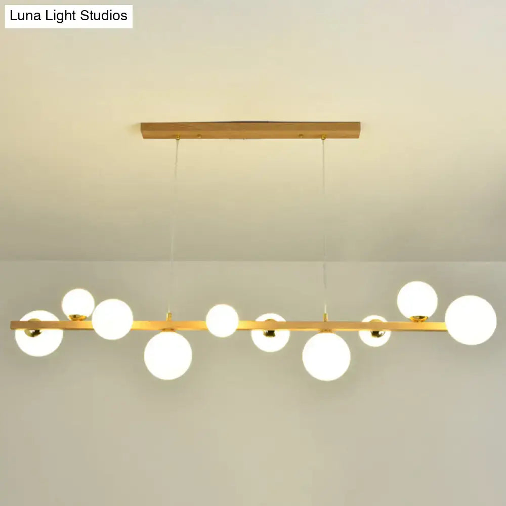 Modern gold and wood pendant with frosted globe shade dining room