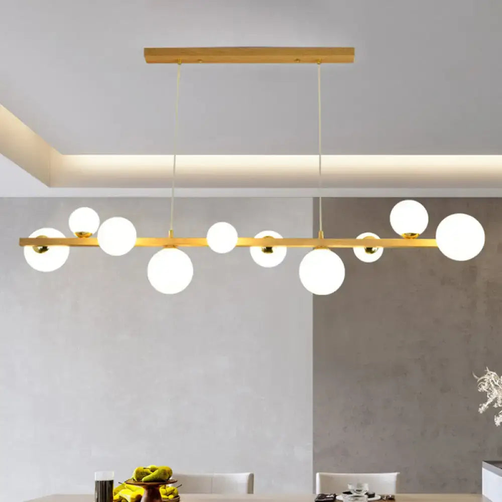 Modern gold and wood pendant with frosted globe shade dining room