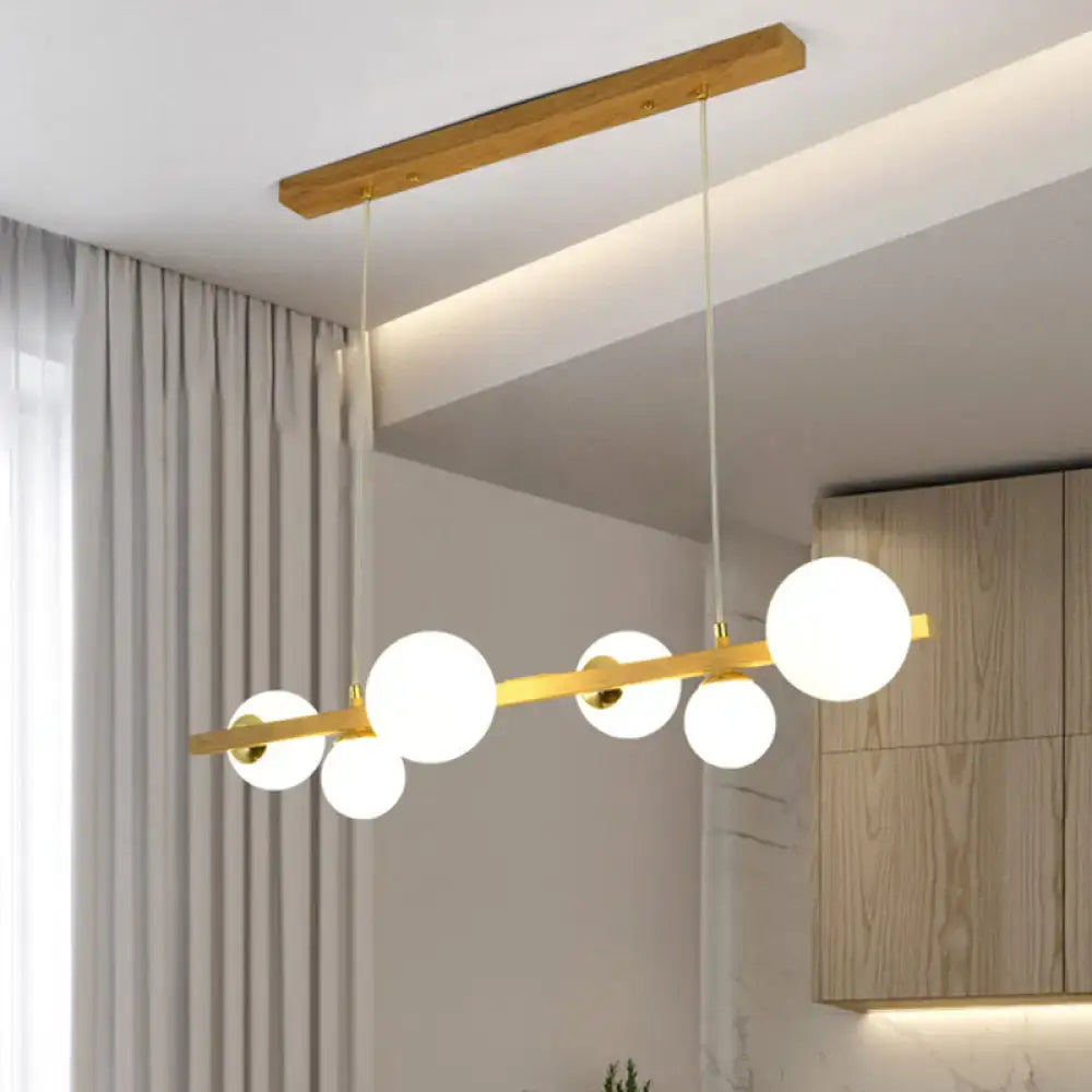 Modern gold and wood pendant with frosted globe shade dining room