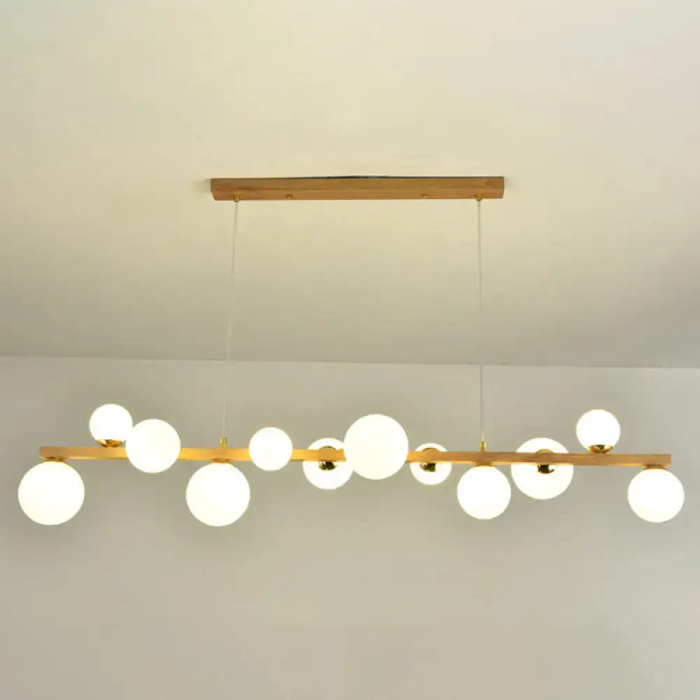 Modern gold and wood pendant with frosted globe shade dining room