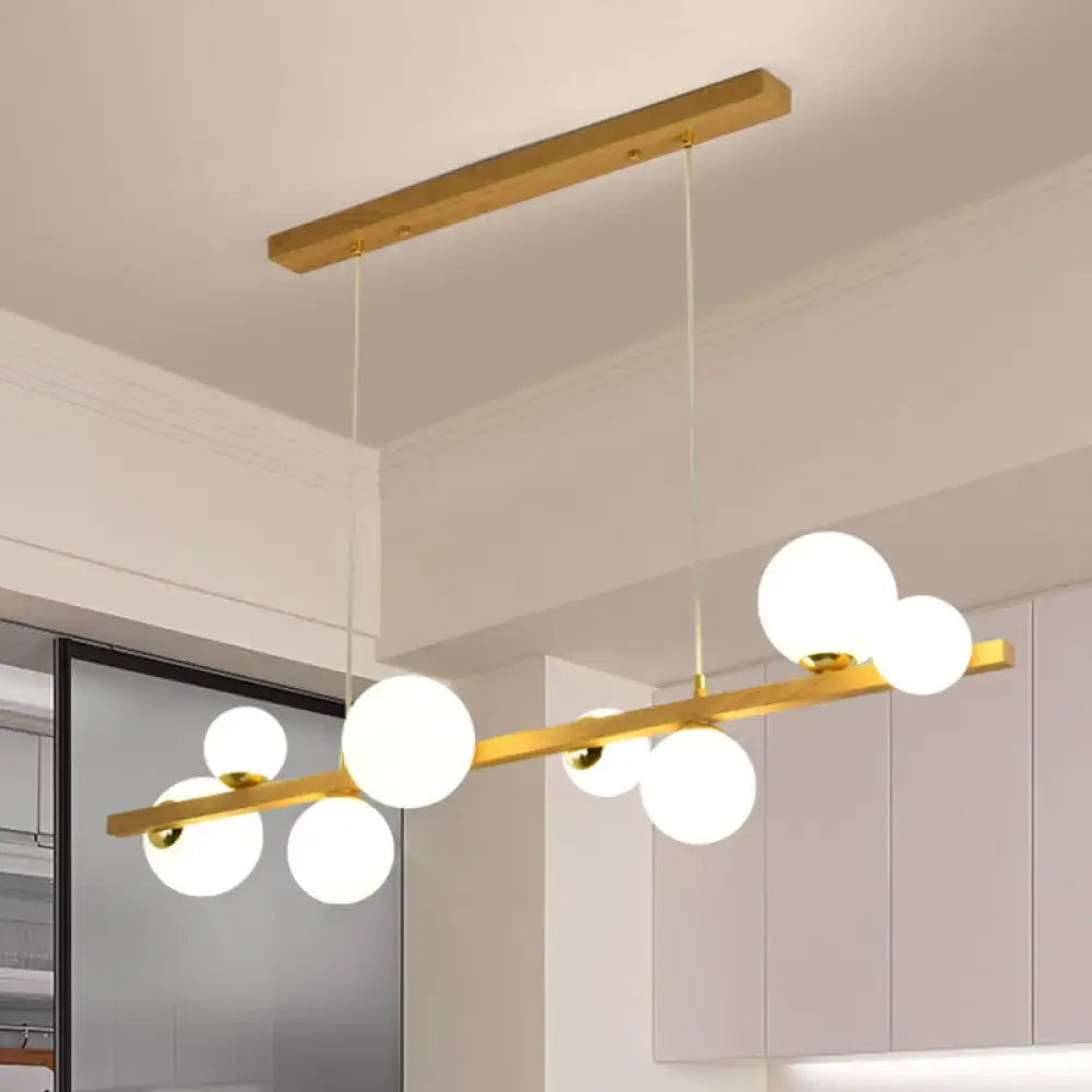 Modern gold and wood pendant with frosted globe shade dining room