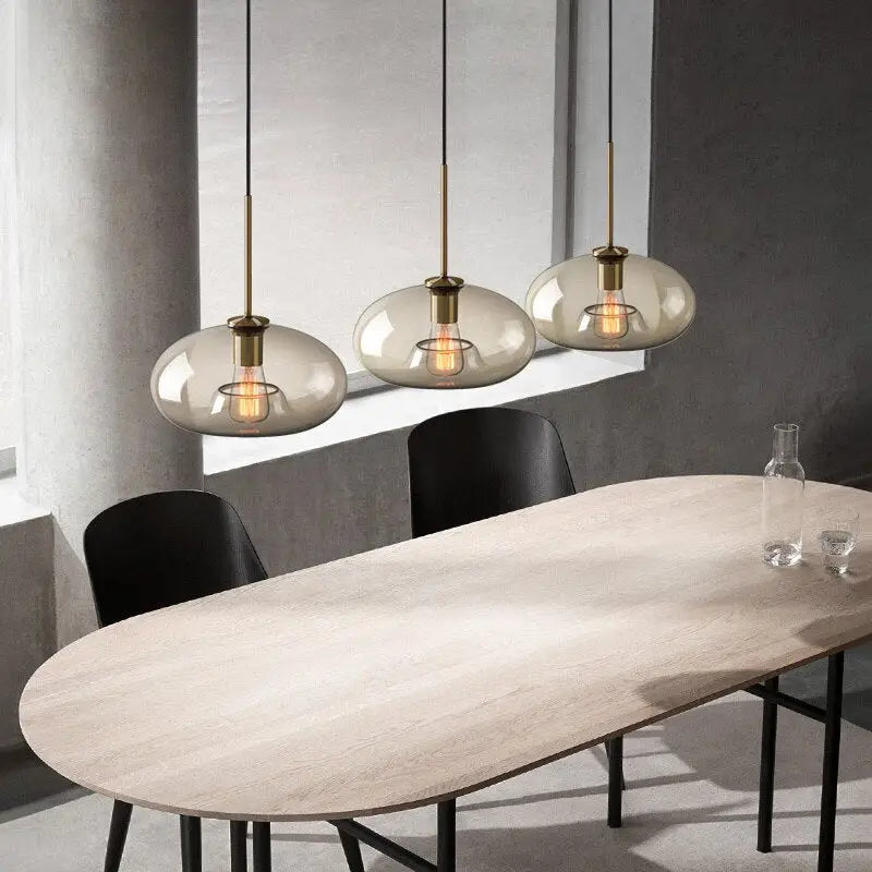 Modern smoked glass pendant lights with brass accents for kitchen island