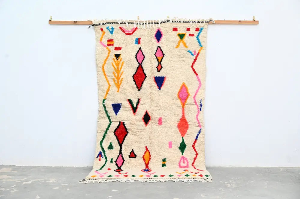 Handmade beige azilal rug with colorful geometric patterns bedroom