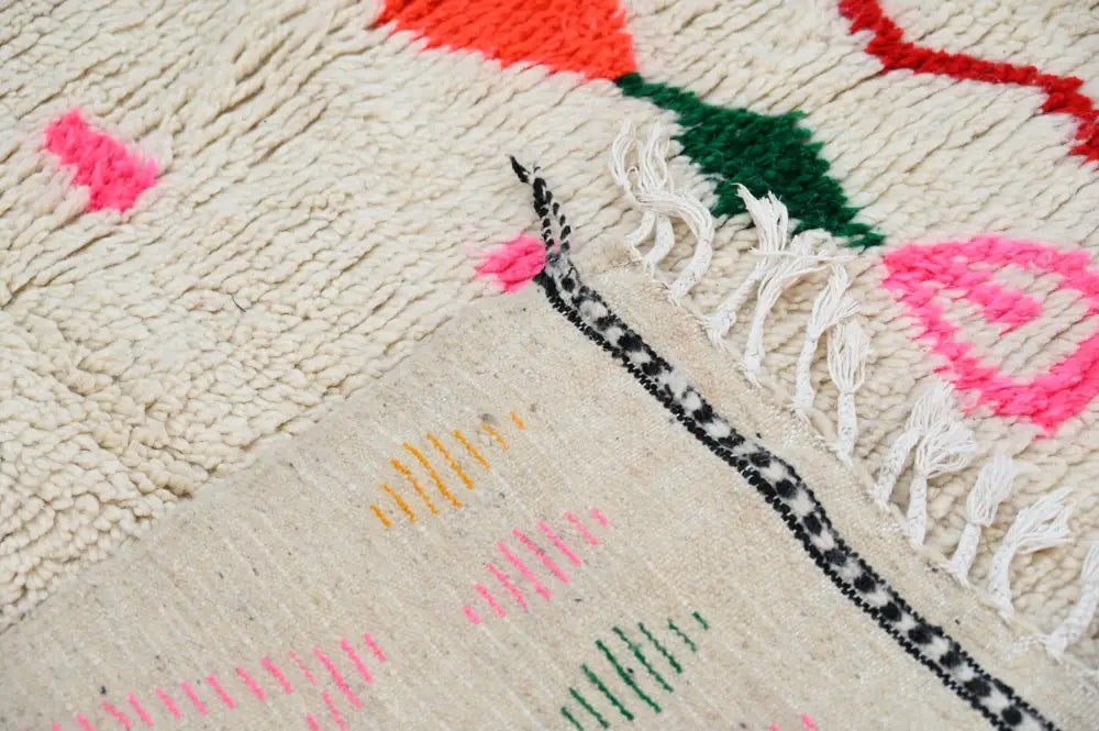 Handmade beige azilal rug with colorful geometric patterns bedroom