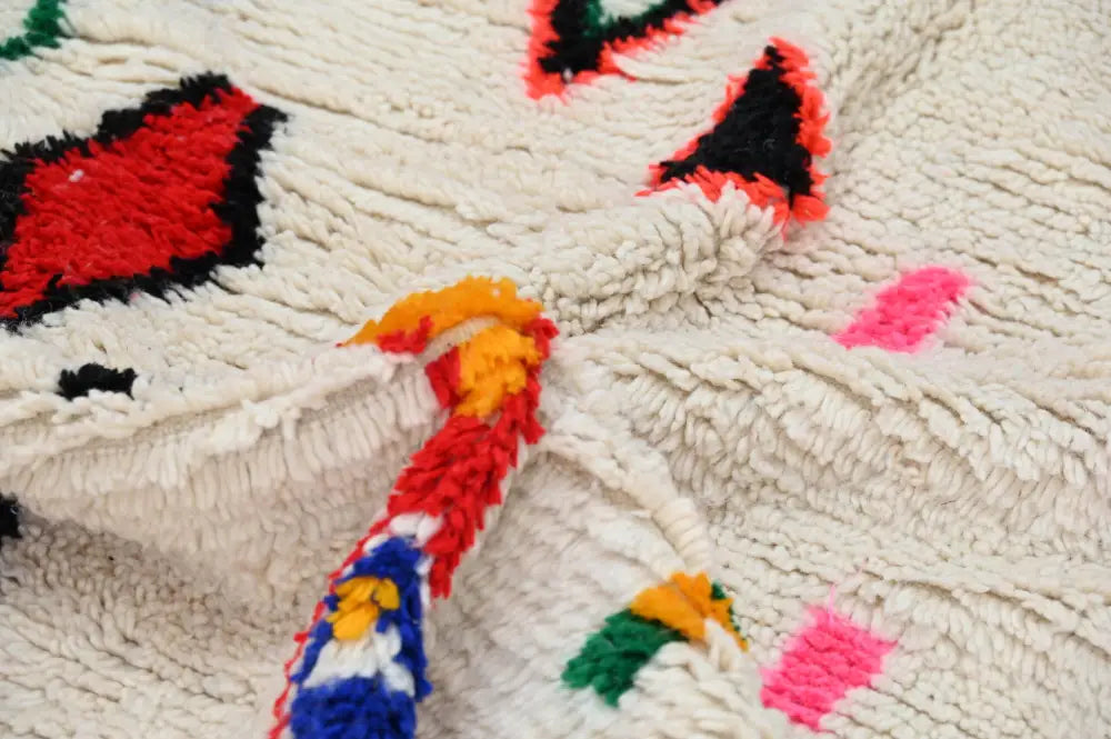 Handmade beige azilal rug with colorful geometric patterns bedroom