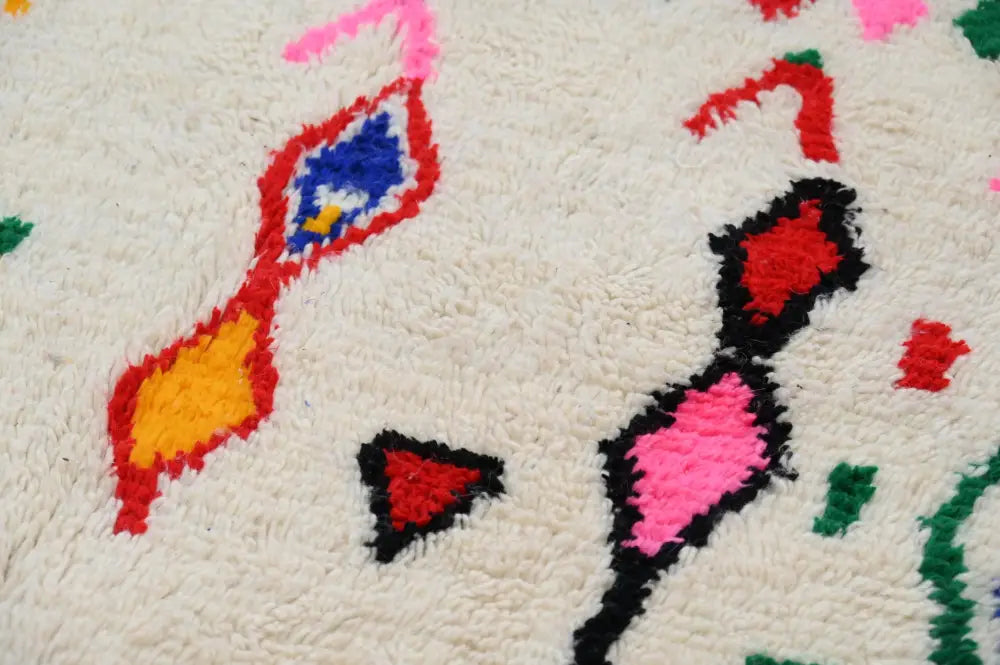 Handmade beige azilal rug with colorful geometric patterns bedroom
