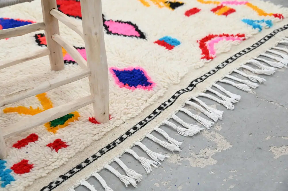 Handmade beige azilal rug with colorful geometric patterns bedroom