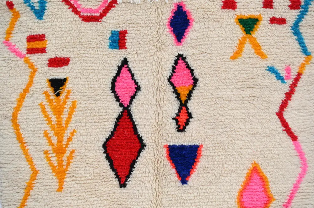 Handmade beige azilal rug with colorful geometric patterns bedroom
