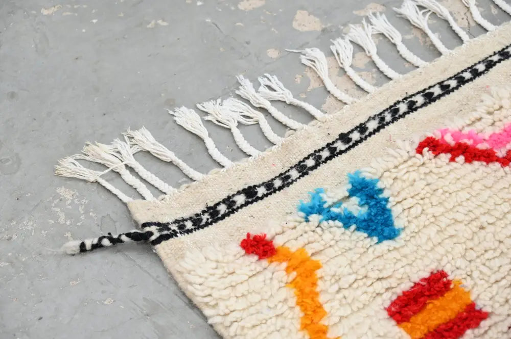 Handmade beige azilal rug with colorful geometric patterns bedroom