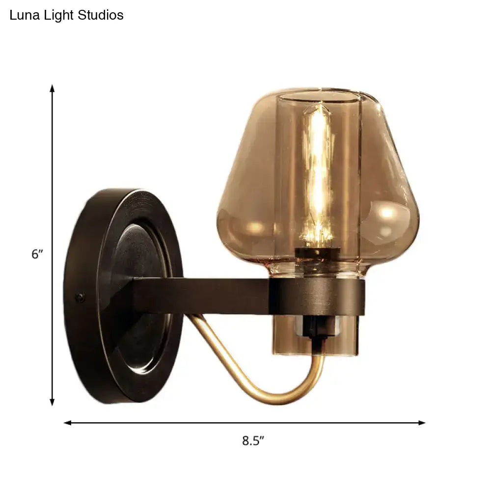 Modern black and brass wall sconce with amber glass bedroom light