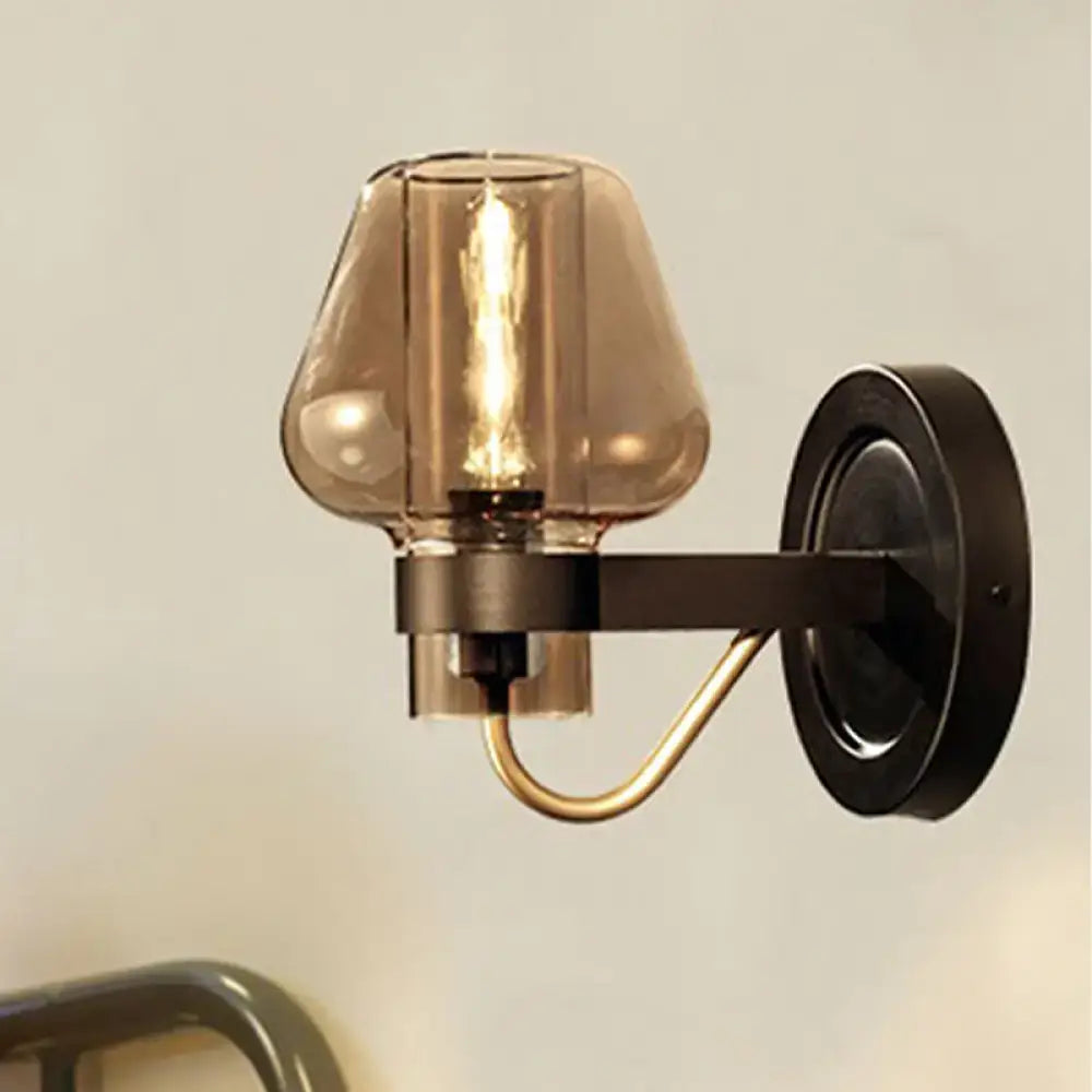 Modern black and brass wall sconce with amber glass bedroom light