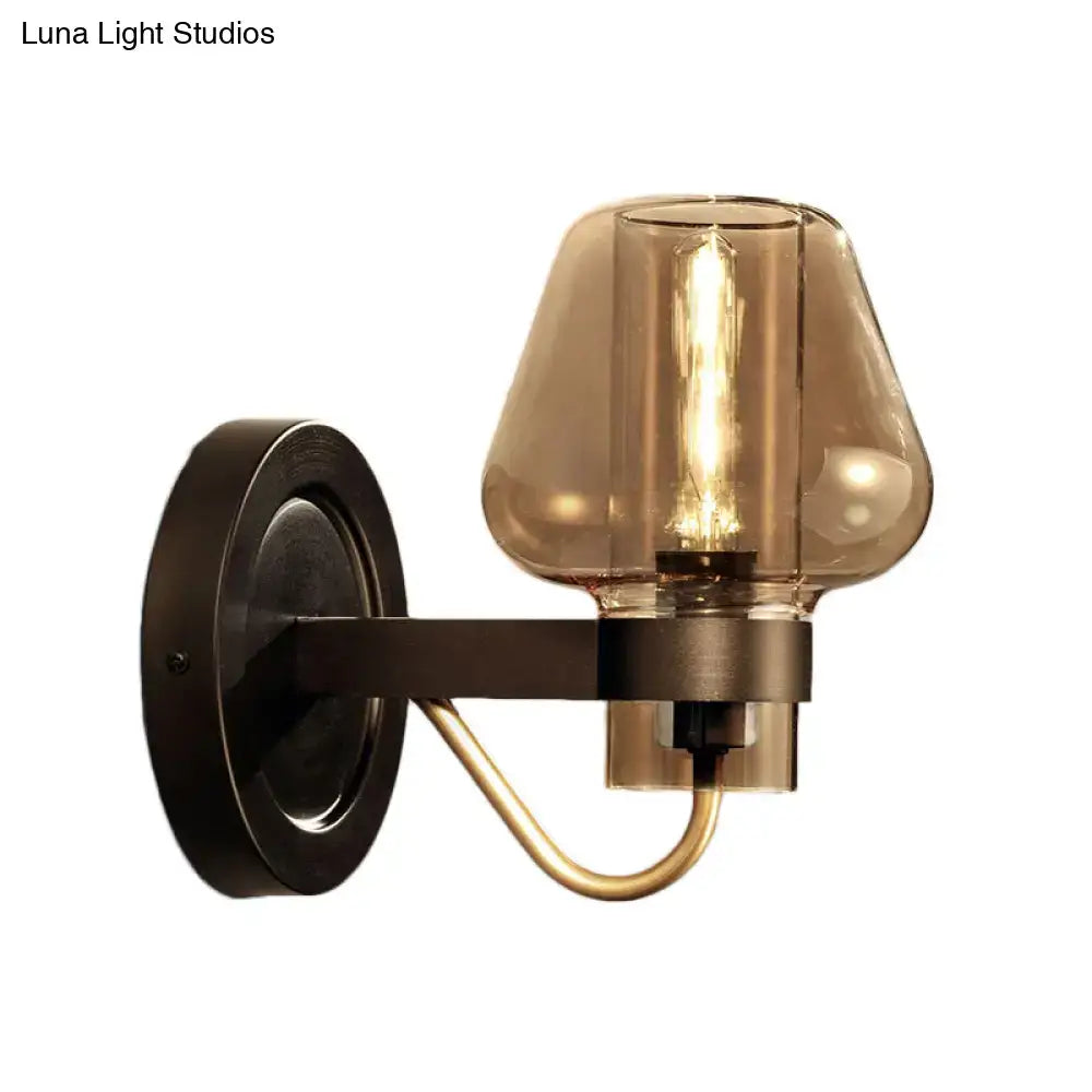 Modern black and brass wall sconce with amber glass bedroom light