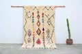 Handmade beige azilal rug with colorful patterns for bedroom