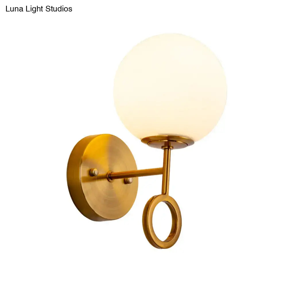 Minimalist brass wall sconce with cream glass shade bedroom light