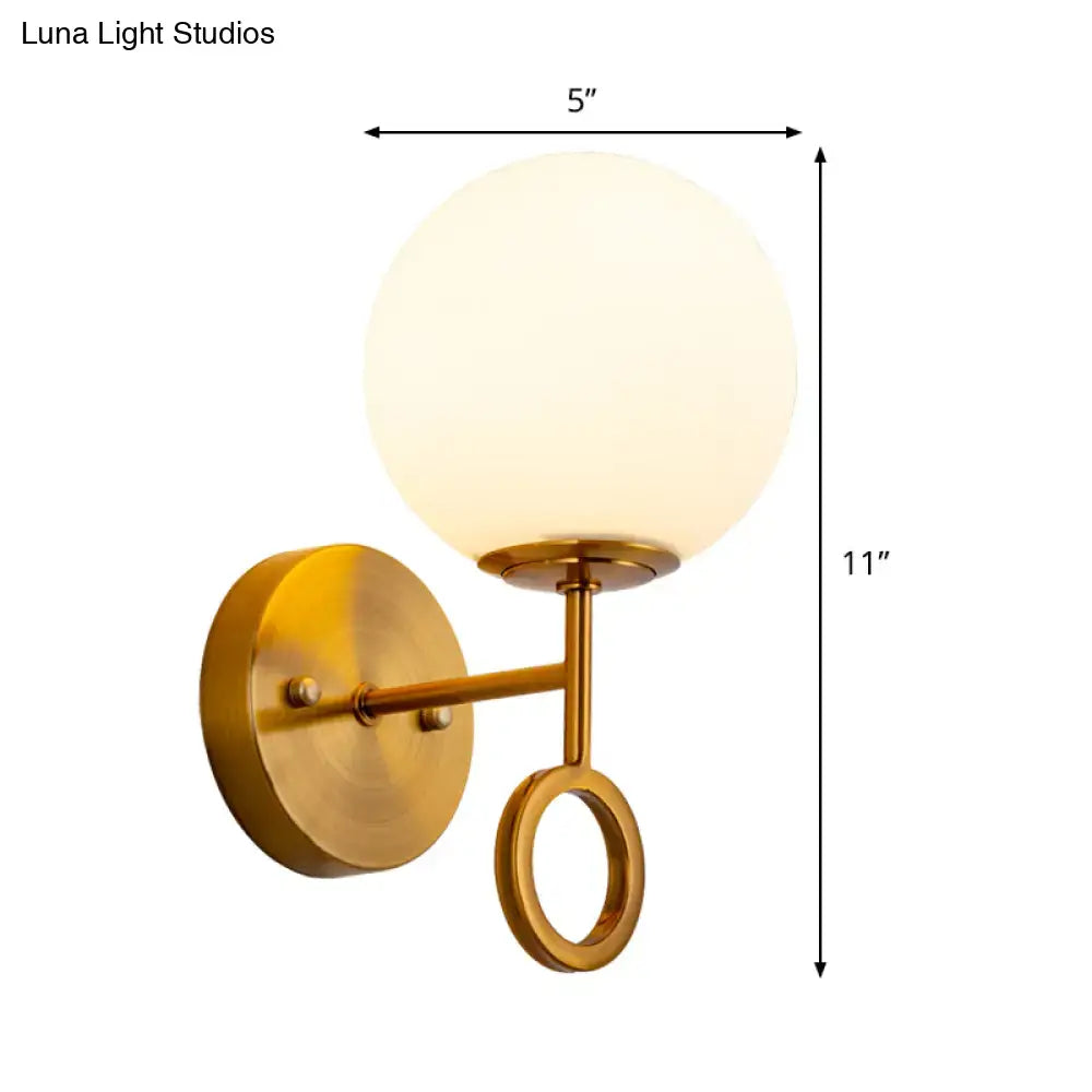 Minimalist brass wall sconce with cream glass shade bedroom light