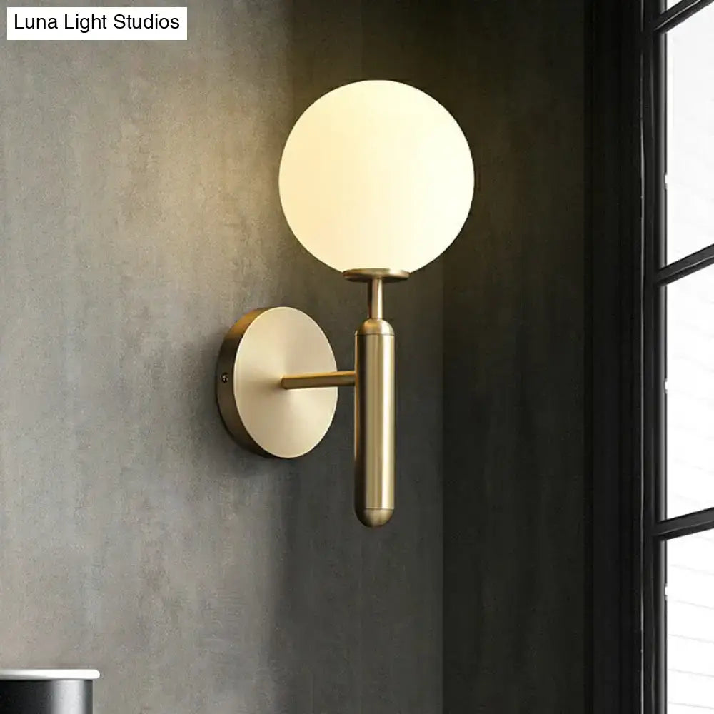 Minimalist brass wall sconce with cream glass shade for living room