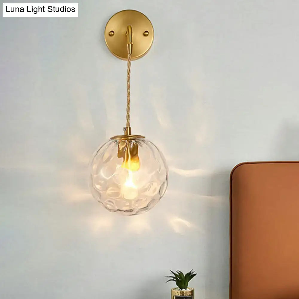 Minimalist gold ball sconce with hammered glass shade bedroom light