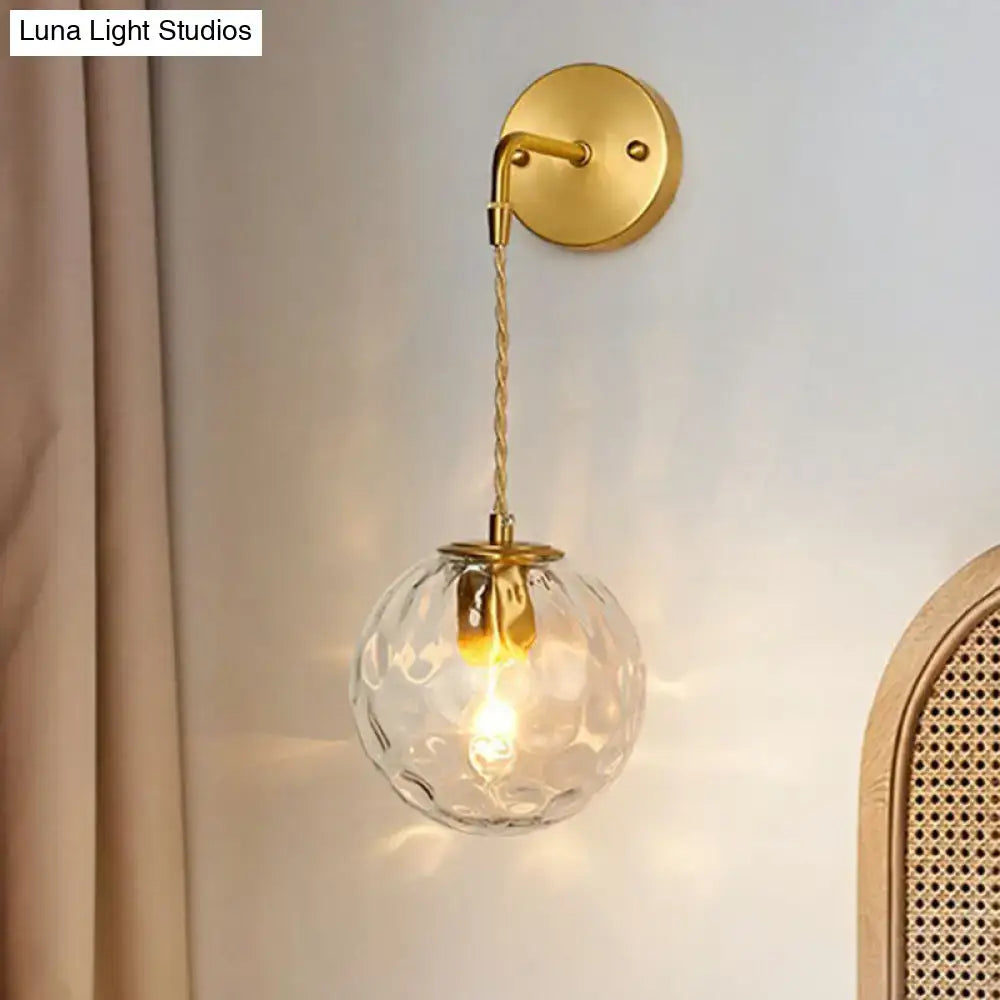 Minimalist gold ball sconce with hammered glass shade bedroom light