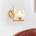 Minimalist gold wall lamp with textured glass globe bedroom fixture
