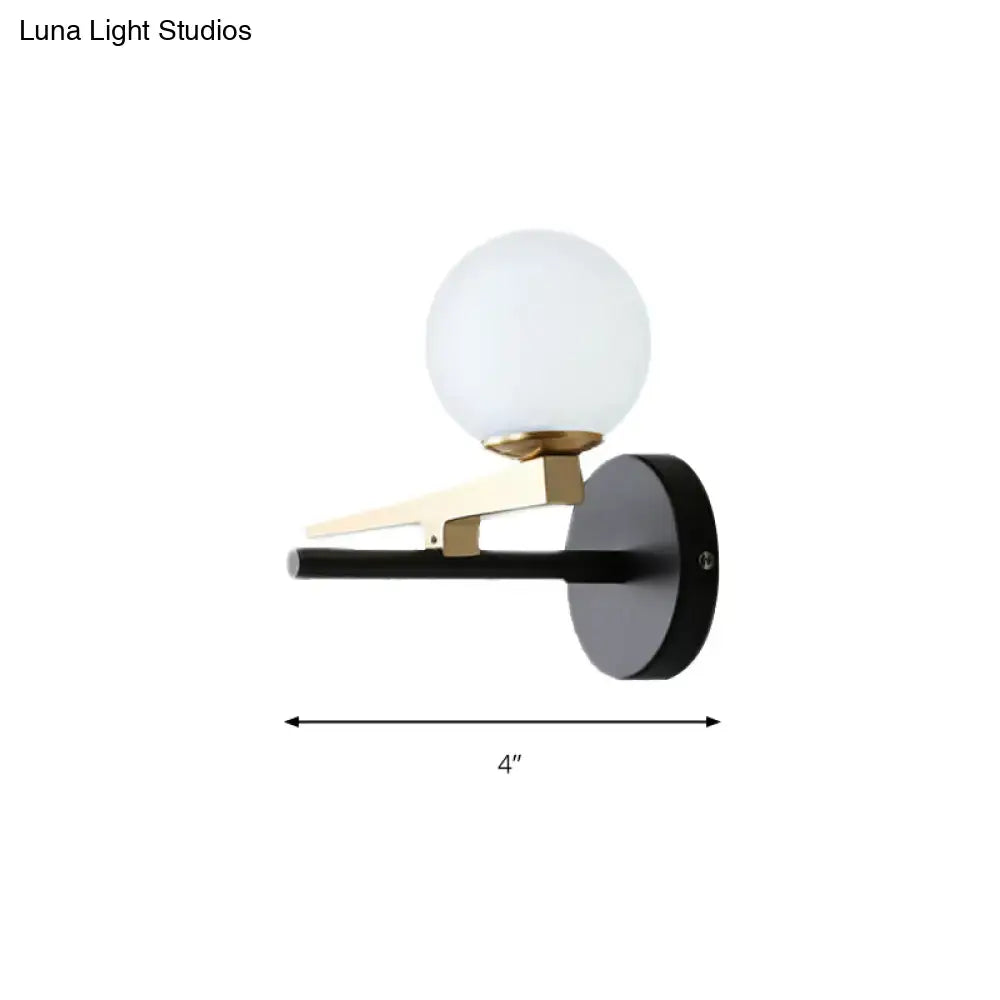Modern black and brass wall sconce with white glass ball shade bedroom