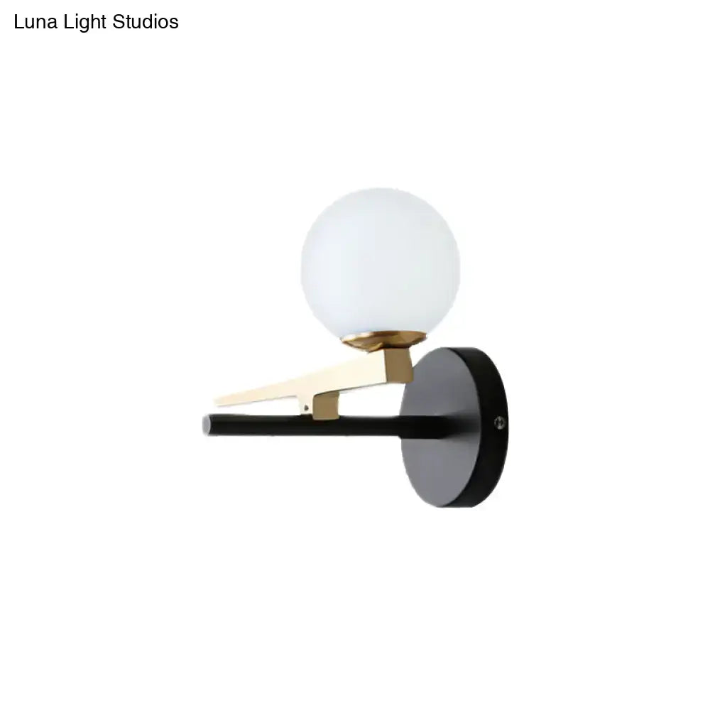 Modern black and brass wall sconce with white glass ball shade bedroom