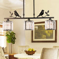 Modern black & gold bird pendant light with clear crystal drum shade