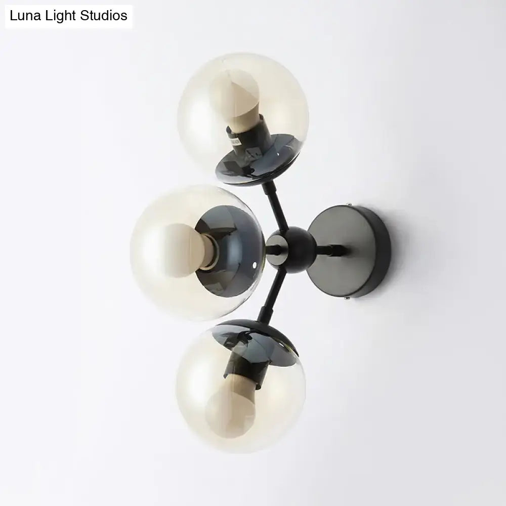 Modern black metal bathroom sconce with three clear glass spheres