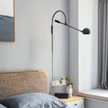 Modern black metal sphere wall sconce with curved arm bedroom light
