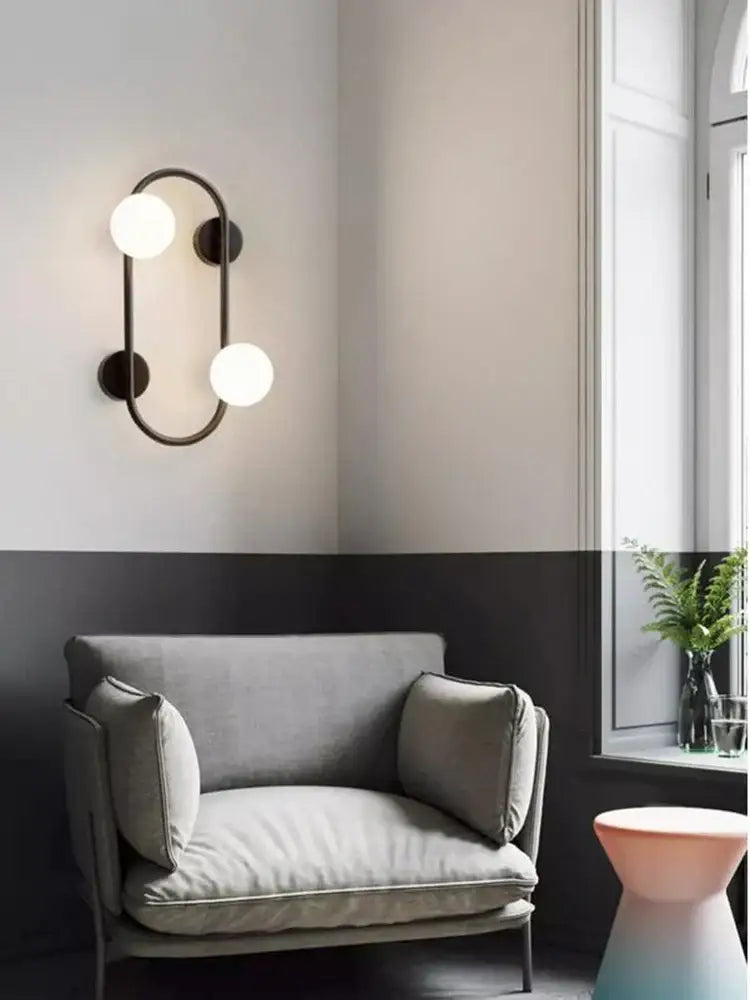 Modern black wall sconce with frosted glass globes – bedroom light