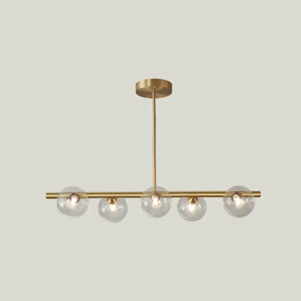 Modern brass 5-light pendant light with spherical glass shade dining room