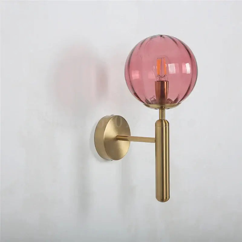 Modern brass and pink glass wall sconce for bedroom
