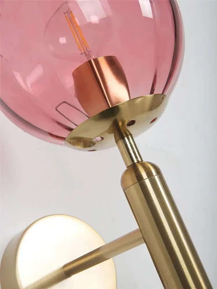 Modern brass and pink glass wall sconce for bedroom