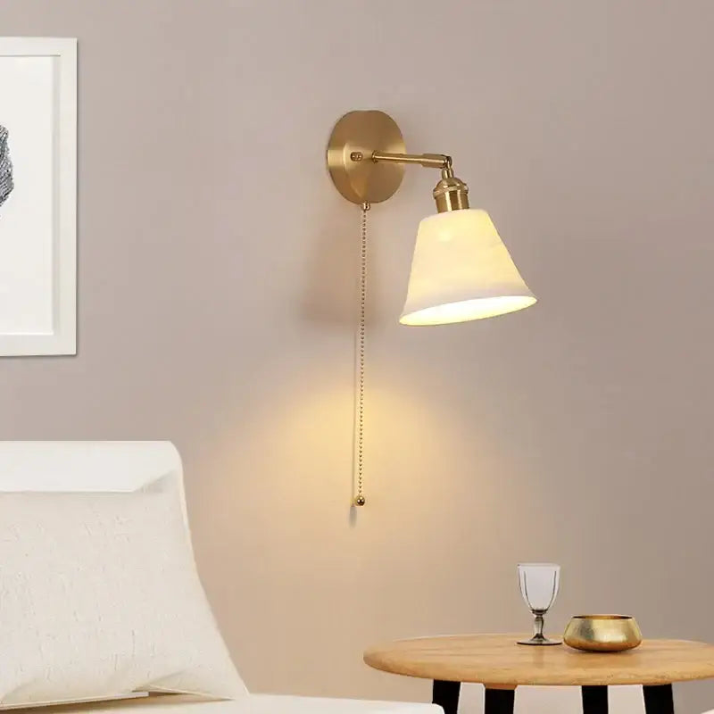 Modern brass wall lamp with frosted glass shade for bedroom reading