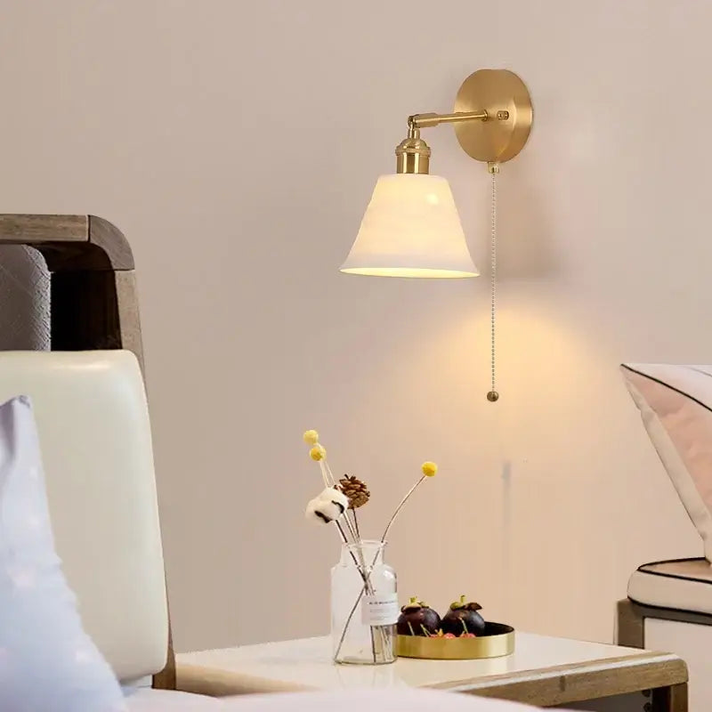 Modern brass wall lamp with frosted glass shade for bedroom reading