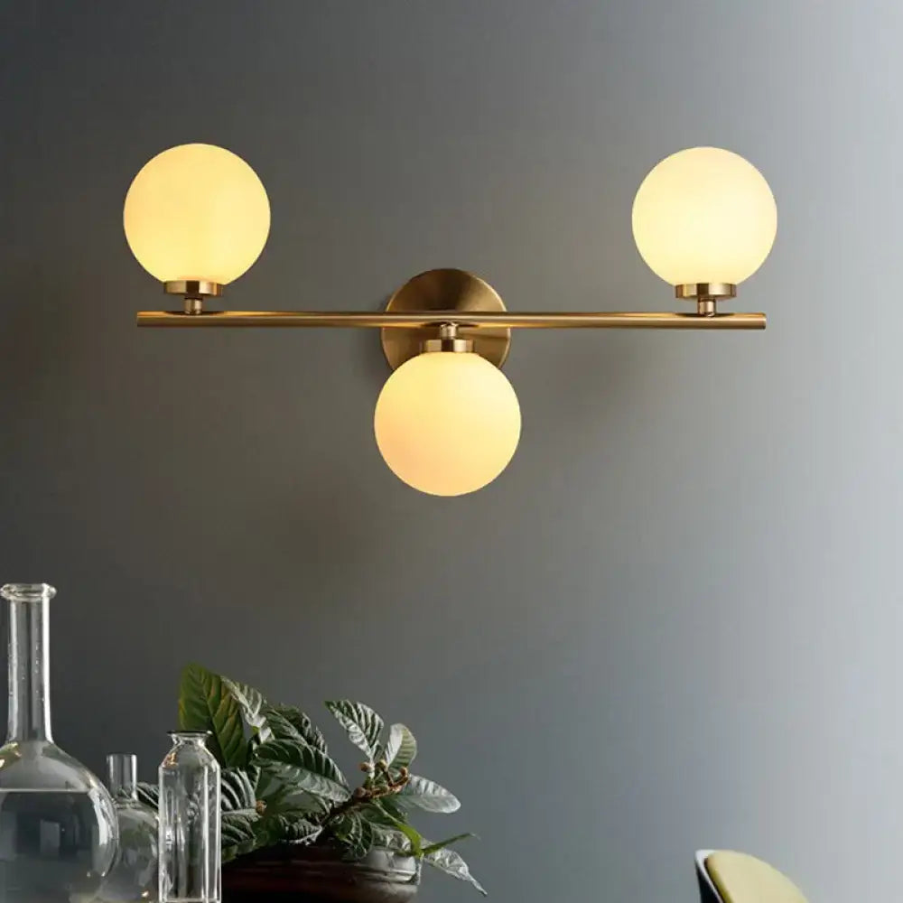 Modern gold 3-light wall sconce with white glass shades for bedroom