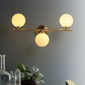 Modern gold 3-light wall sconce with white glass shades for bedroom