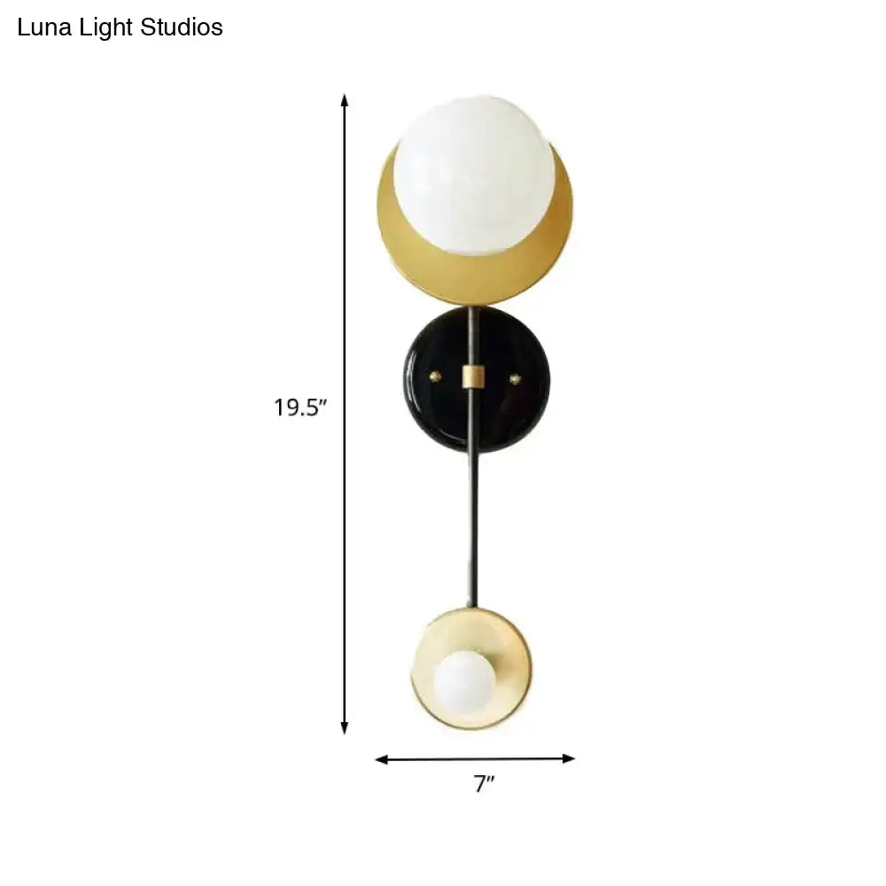 Modern gold and black wall sconce with opal glass shade bedroom light