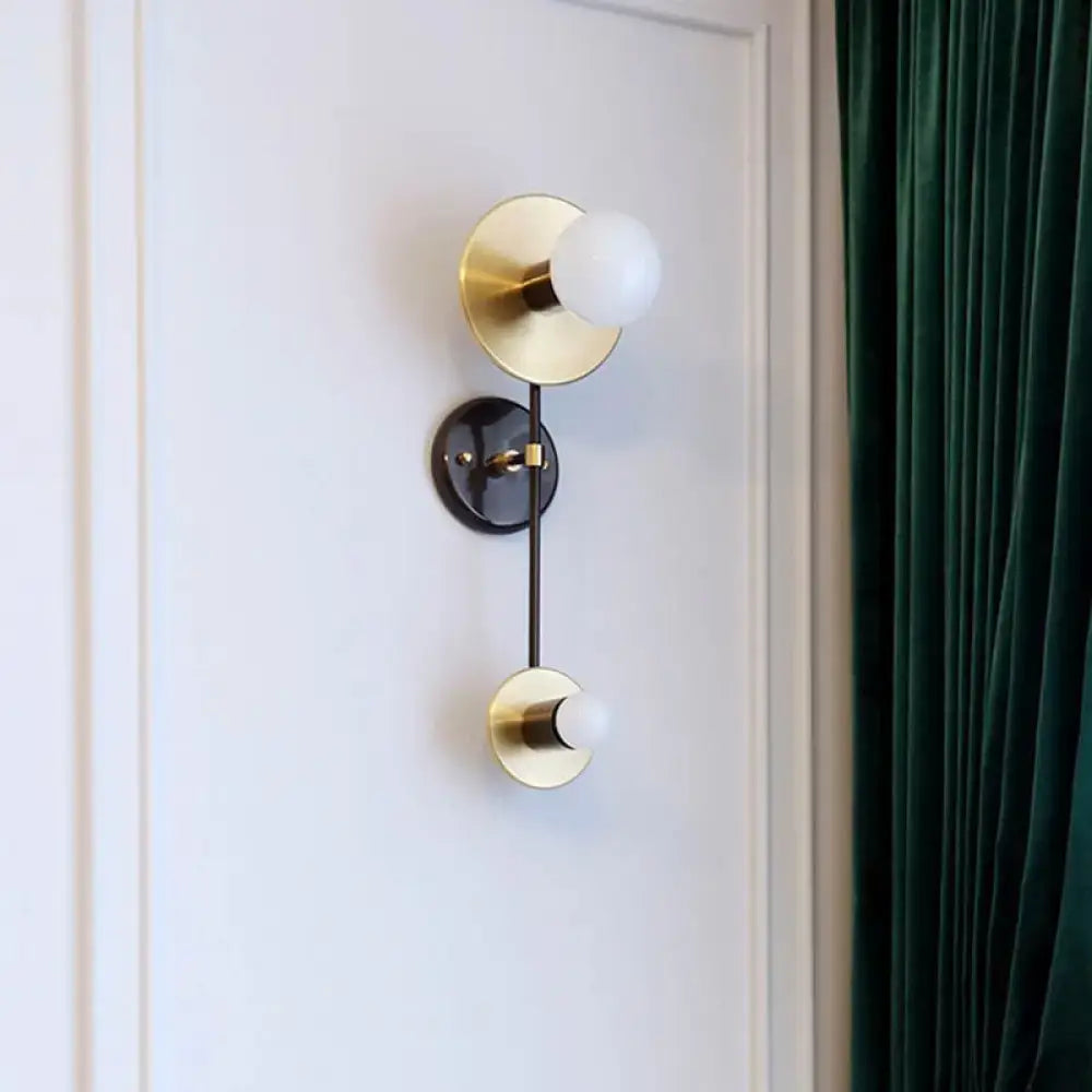Modern gold and black wall sconce with opal glass shade bedroom light