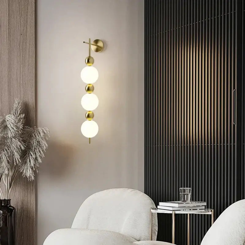 Modern gold led wall sconce with frosted glass spheres for bedroom