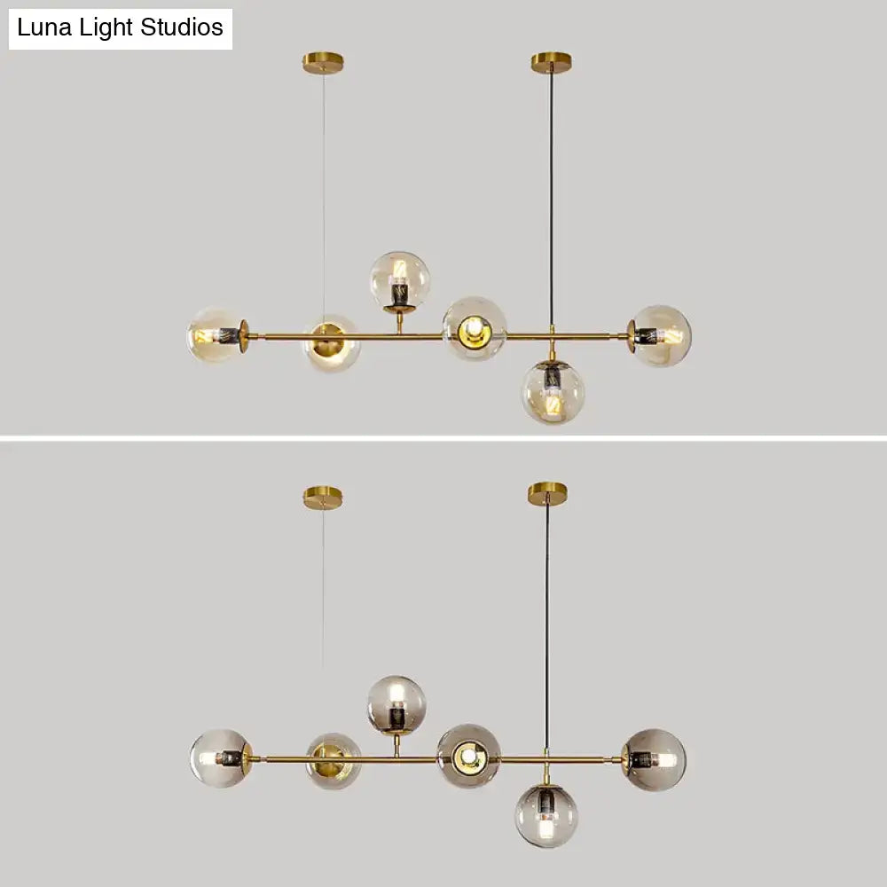 Modern gold metal island pendant with blue glass spheres dining room