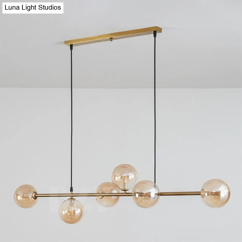 Modern gold metal island pendant with blue glass spheres dining room