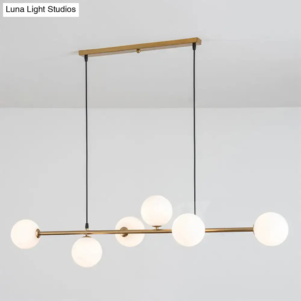 Modern gold metal island pendant with blue glass spheres dining room
