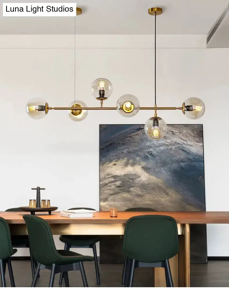 Modern gold metal island pendant with blue glass spheres dining room