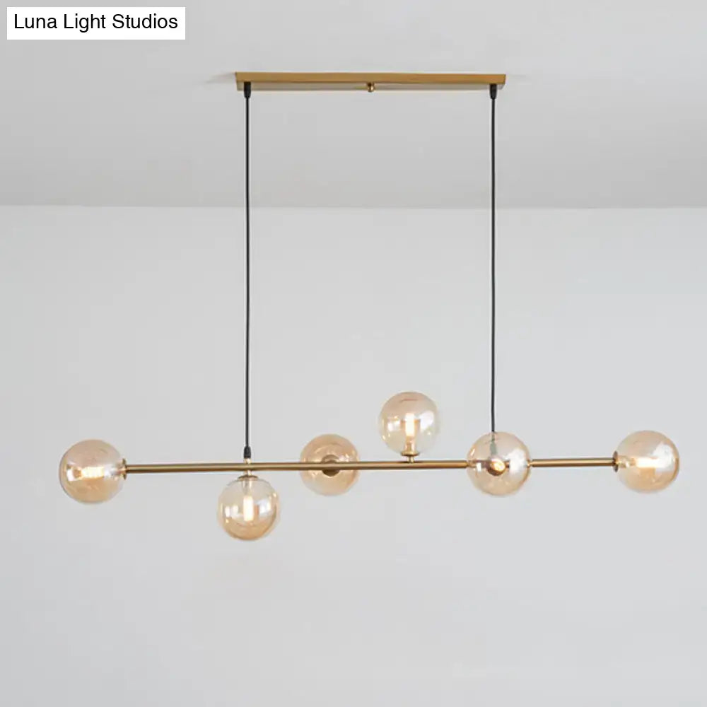 Modern gold metal island pendant with blue glass spheres dining room