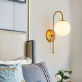 Modern golden gooseneck wall sconce with frosted glass ball bedroom
