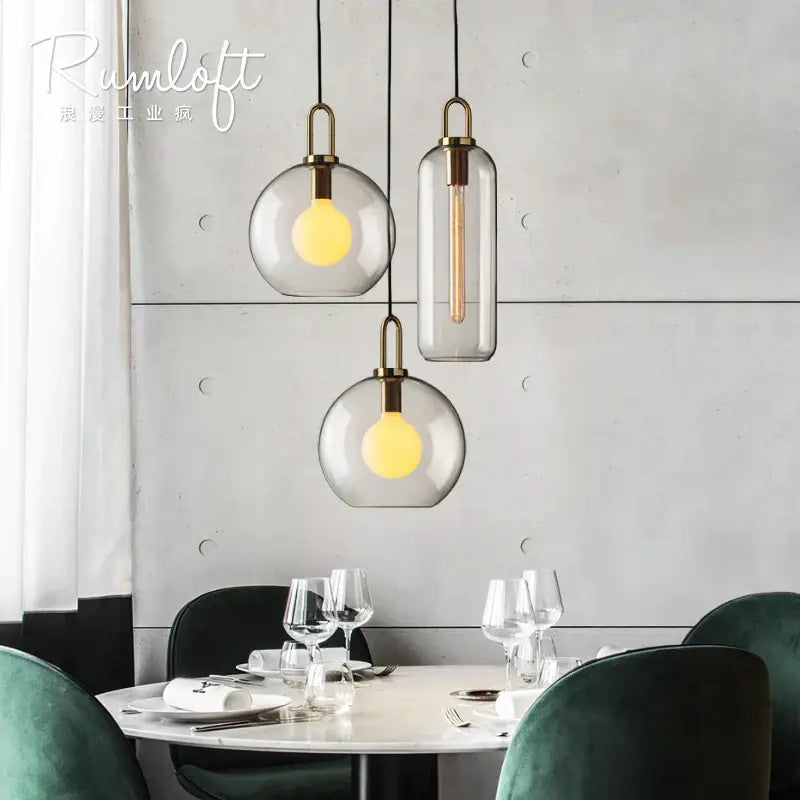 Modern gray glass ball pendant lights – dining room brass accents