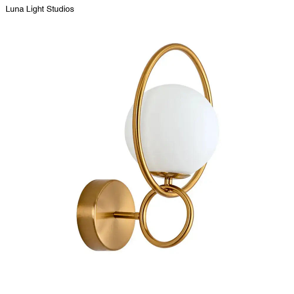 Modernist gold wall sconce with white glass shade for bedroom