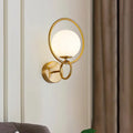 Modernist gold wall sconce with white glass shade for bedroom