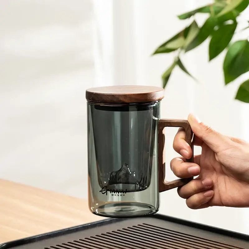 Sleek dark gray double walled glass tea cup with wooden lid kitchen